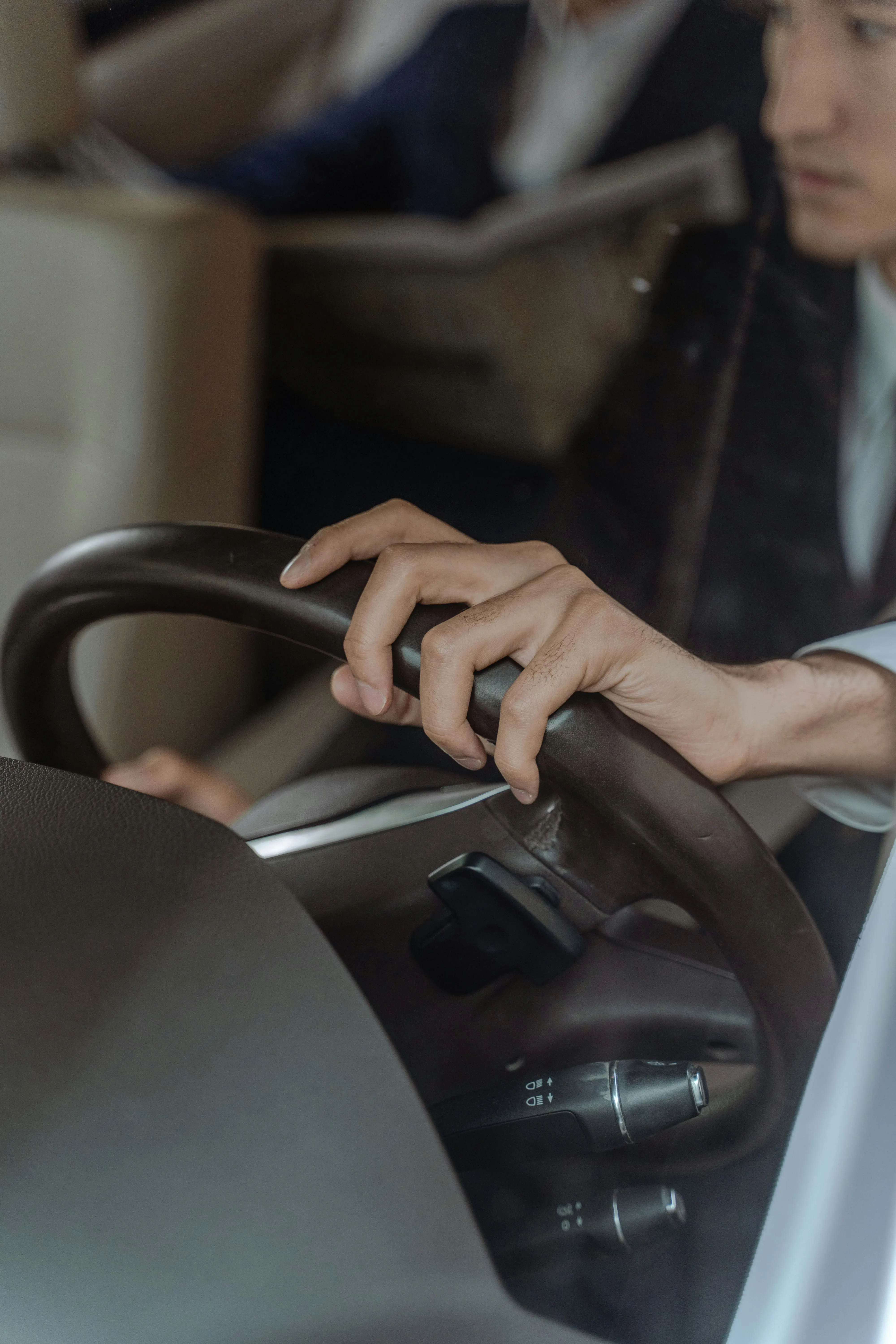 Hands holding the steering wheel of a car.